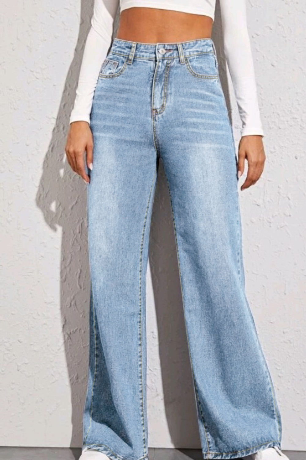 Woman wearing light blue high waist wide leg jeans with basic style and no stretch