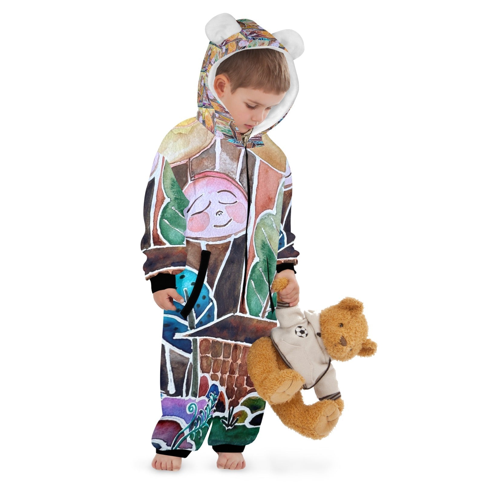 Child wearing a colorful one piece kids hooded pajama with original painted designs holding a teddy bear.