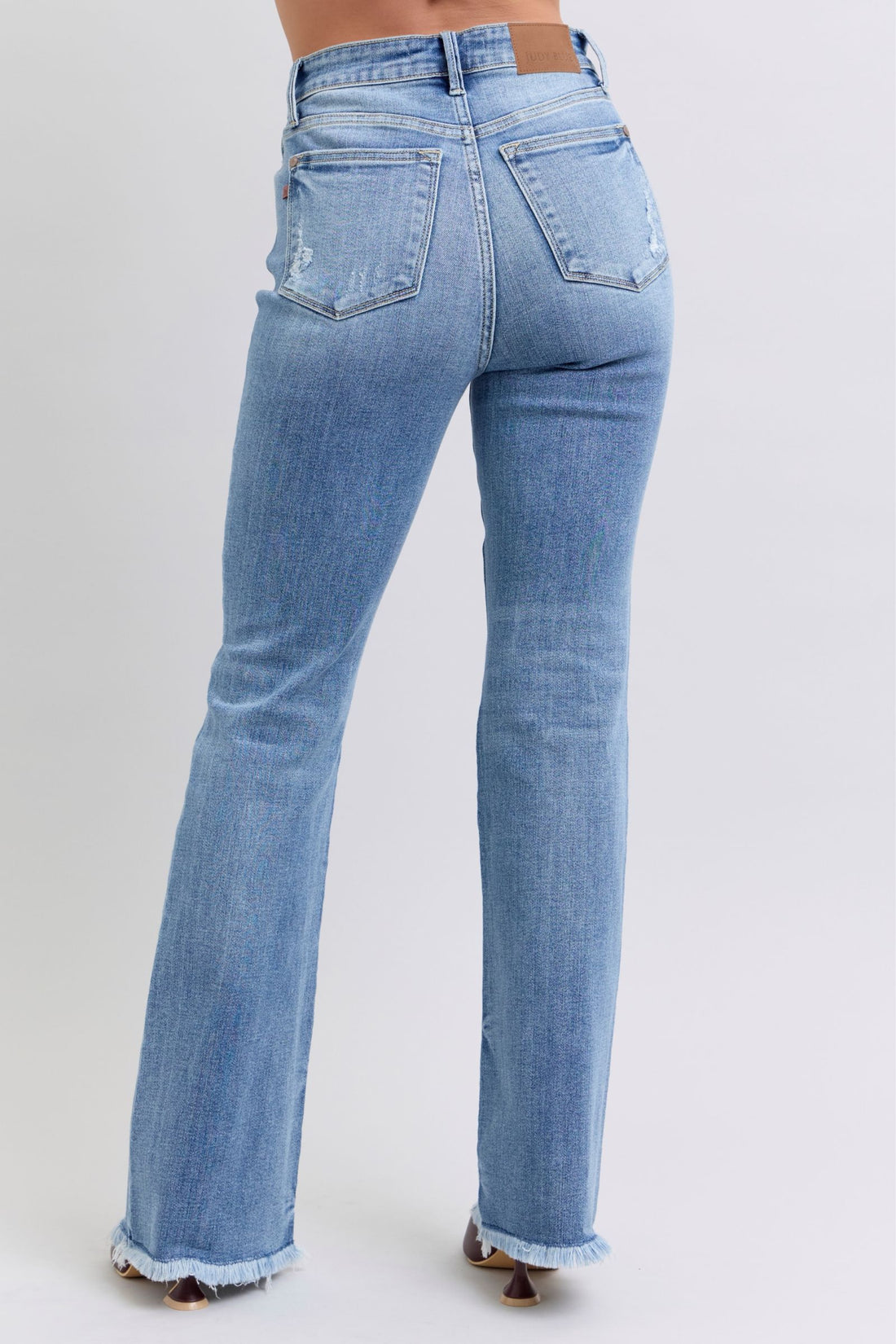Light blue Judy Blue raw hem high rise bootcut jeans with moderate stretch and classic five-pocket design.