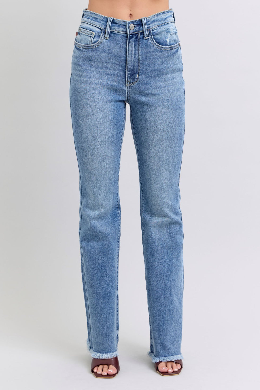 Light blue Judy Blue raw hem high rise bootcut jeans with moderate stretch and classic five-pocket design.