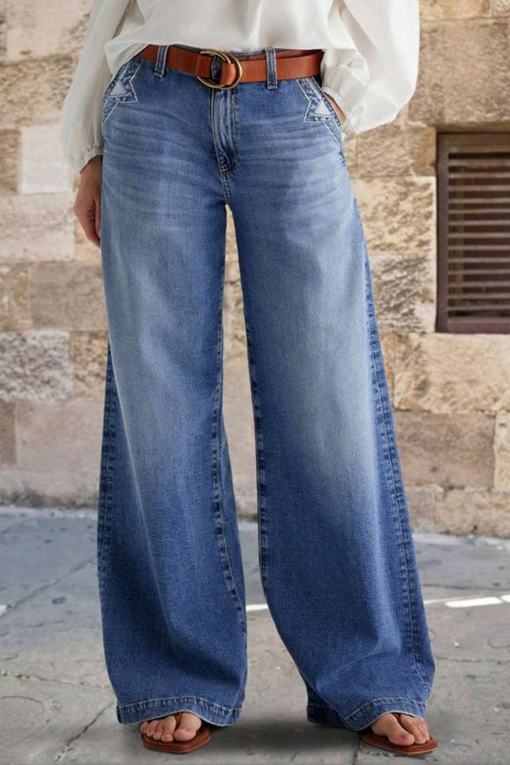 Pocketed embroidered straight leg jeans in blue denim with brown belt and casual footwear