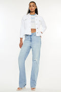 Woman wearing Kancan distressed high waist light blue straight jeans with a white cropped jacket and heels